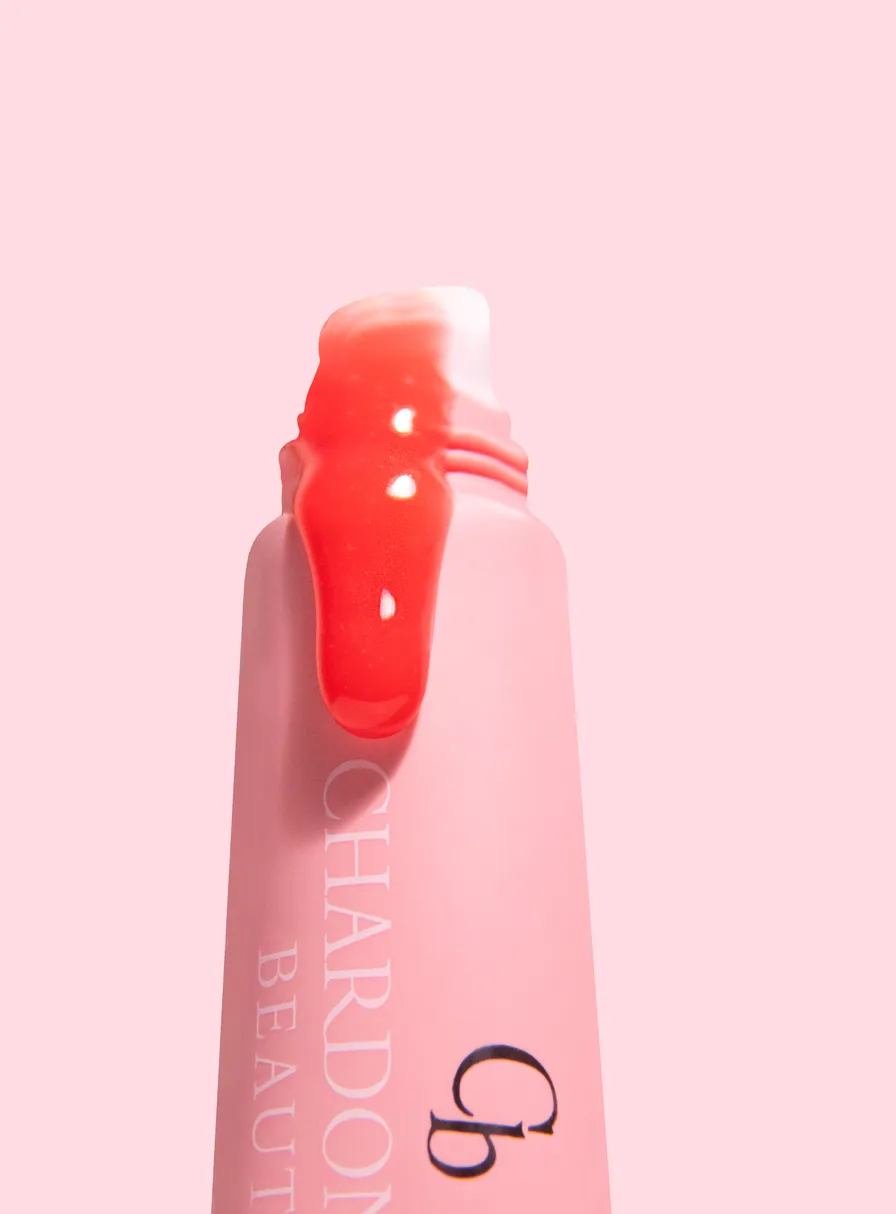 A pink Chardonnay Beauty tube with a glossy coral-pink tint drawn across its applicator tip